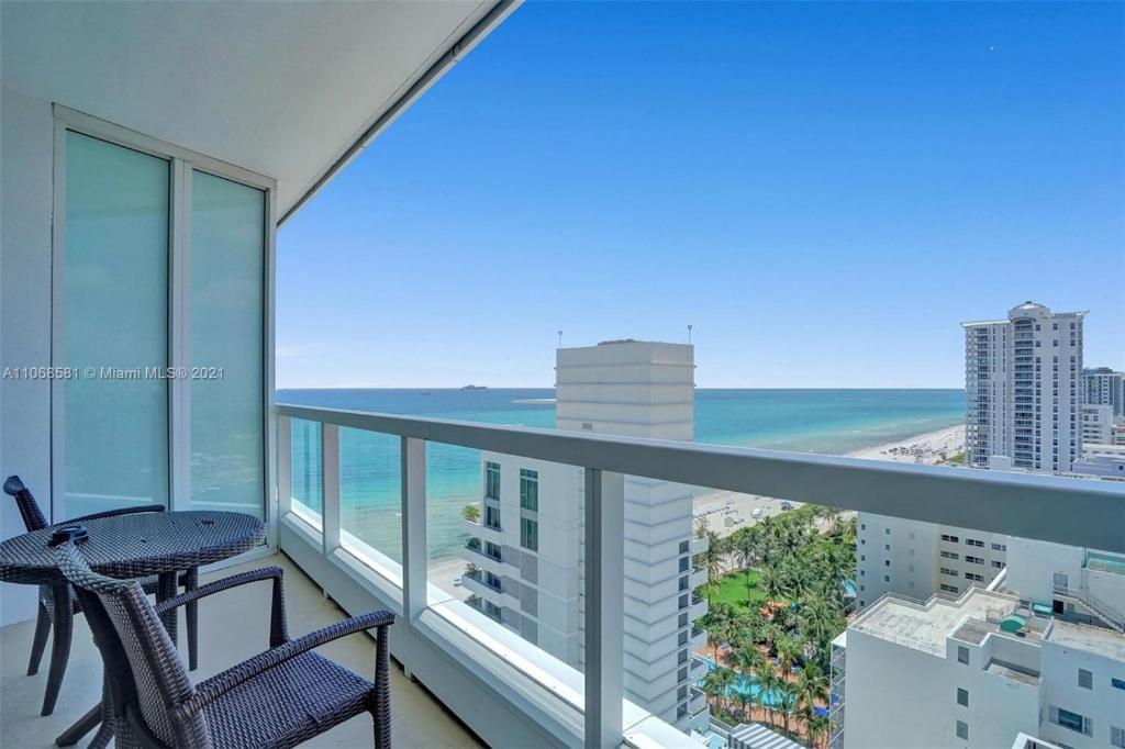 einen Balkon mit einem Tisch, Stühlen und Meerblick in der Unterkunft Fontainebleau Miami Beach in Miami Beach