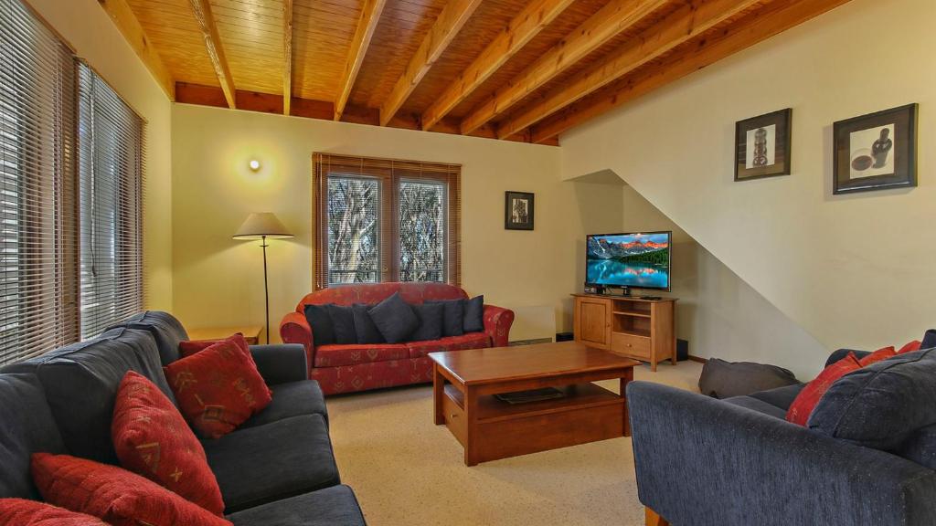 a living room with two couches and a tv at Deep Powder in Dinner Plain