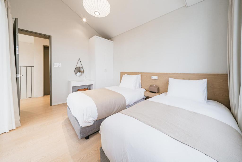 Postel nebo postele na pokoji v ubytování Ddosi Aewol Pool Villa