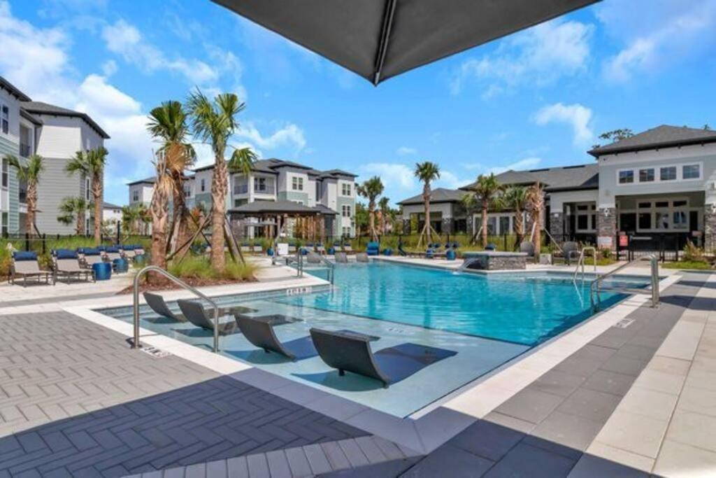 a pool at a resort with palm trees and houses at LuxAprt NearAirport&StJohnsRiver in Jacksonville