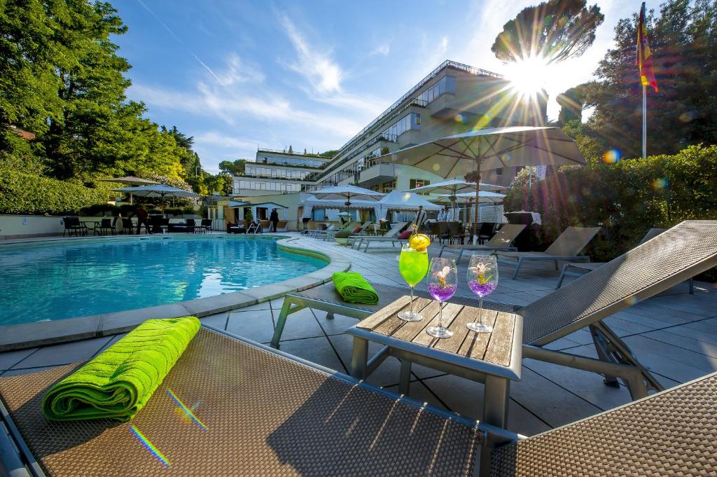 a pool with a table and chairs next to a building at Cardinal Hotel St. Peter in Rome