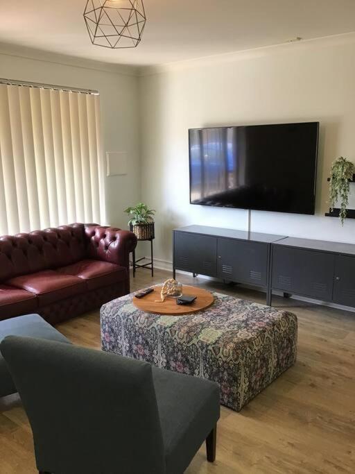 ein Wohnzimmer mit einem großen Flachbild-TV in der Unterkunft Hyacinth Egan in Kalgoorlie