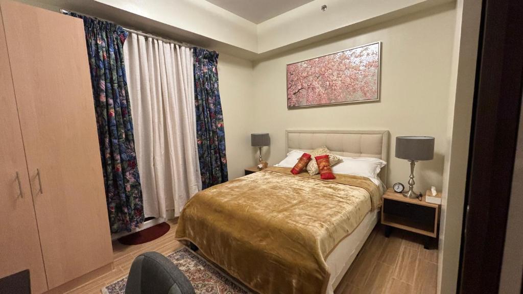 um quarto com uma cama com duas almofadas vermelhas em Saint Honore Condominium em Iloilo