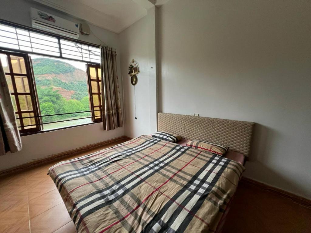 sypialnia z łóżkiem z kocem i oknem w obiekcie Lĩnh Hương Riverside Homestay and Travel w mieście Làng Lap