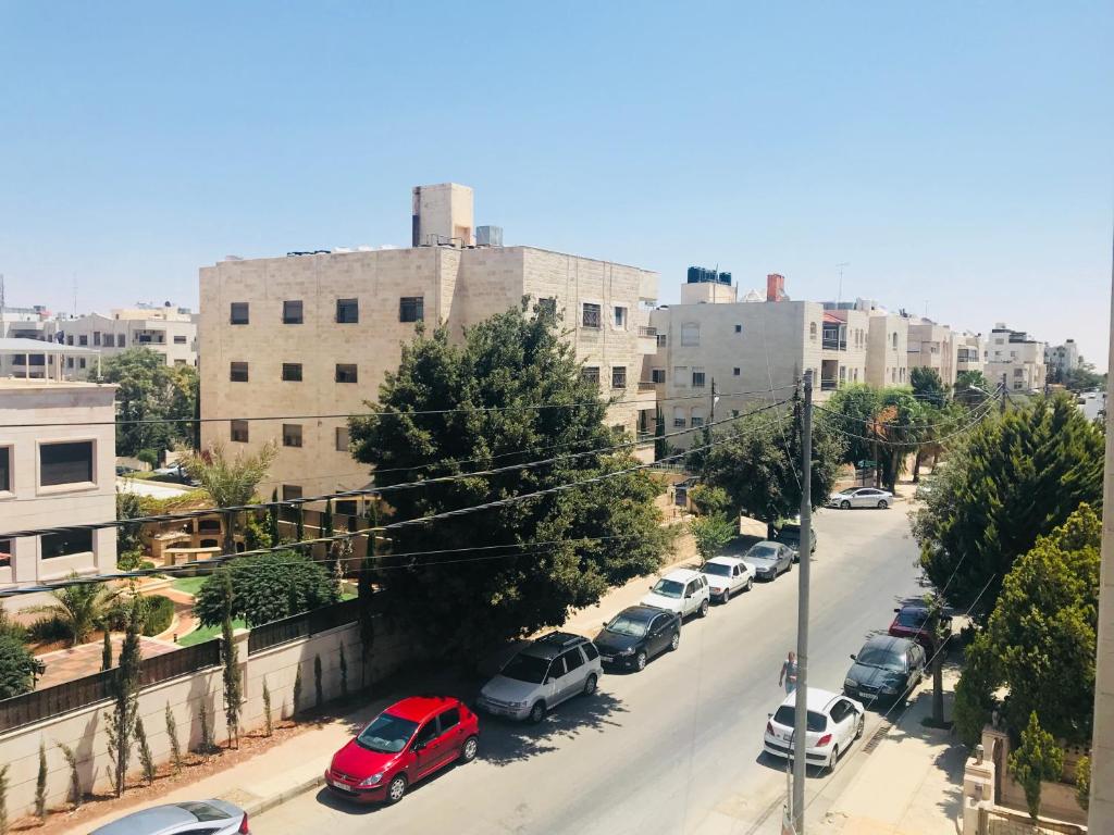 - une vue sur une rue avec des voitures garées dans une ville dans l'établissement Um Uthaina Place, à Amman