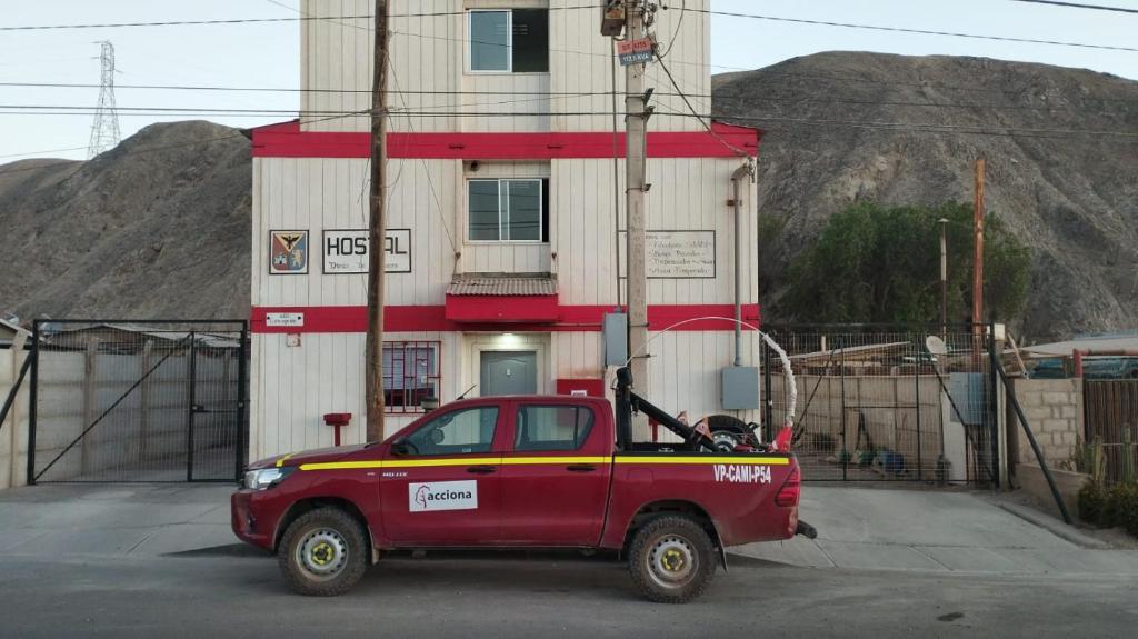 un camión rojo estacionado frente a un edificio en HOSTAL DIEGO DE ALMAGRO, en Diego de Almagro