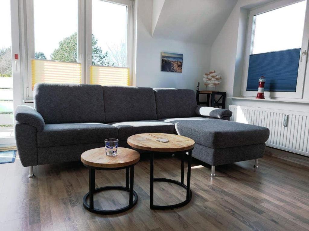 a living room with a couch and two tables at Ferienwohnung-Min-Droom in Sankt Peter-Ording