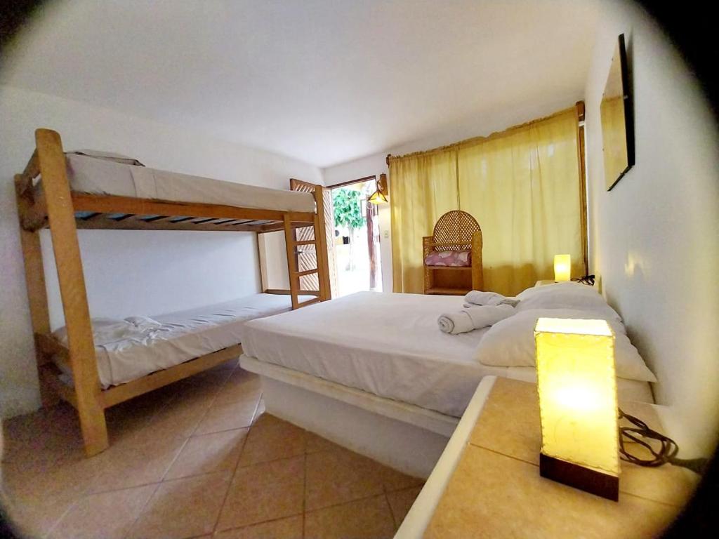 a bedroom with two bunk beds and a lamp at Habitaciones en Vichayito in Vichayito