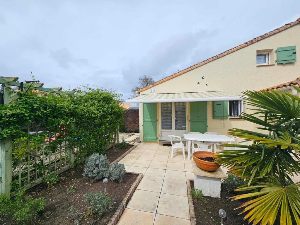 Cette maison dispose d'une terrasse avec une table dans la cour. dans l'établissement Maison avec Piscine, Tennis et Lac - Proche Forêt et Plages - Les Mathes - FR-1-550-72, aux Mathes