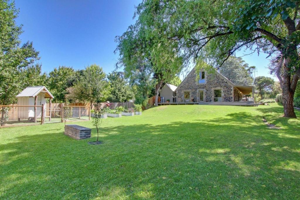 a large yard with a house and a tree at Quigtoo Cottage in Berridale