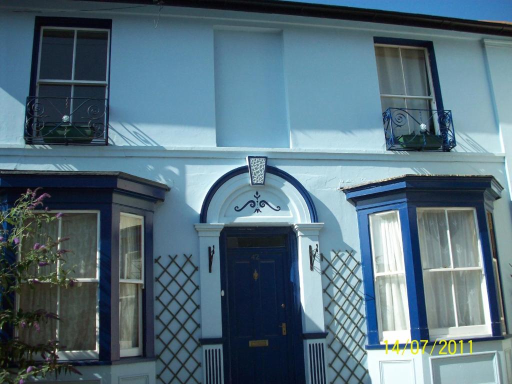 una casa azul con una puerta y ventanas negras en Homeleigh Apartments- Isle of Wight en Ryde