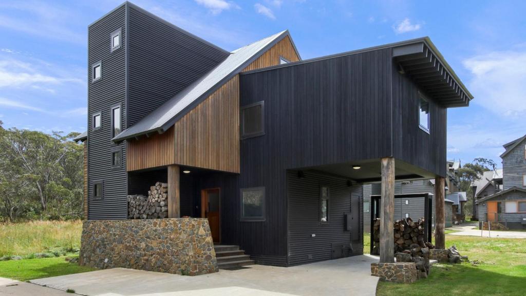 a black house with a gambrel roof at Woodrun in Dinner Plain