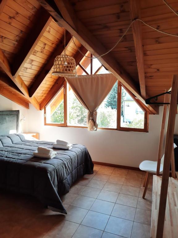 ein Schlafzimmer mit einem Bett in einem Zimmer mit Holzdecken in der Unterkunft Departamento céntrico in San Martín de los Andes