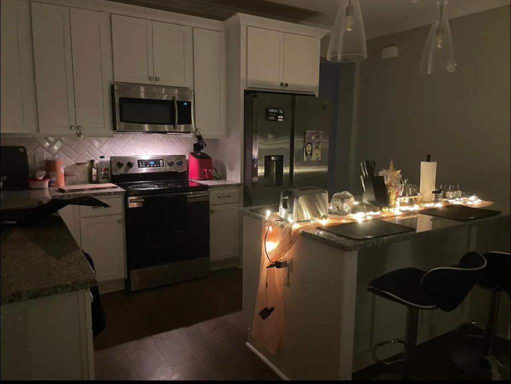 een keuken met witte kasten en apparatuur met kerstverlichting bij Murfreesboro one Bedroom only with shared space in Murfreesboro