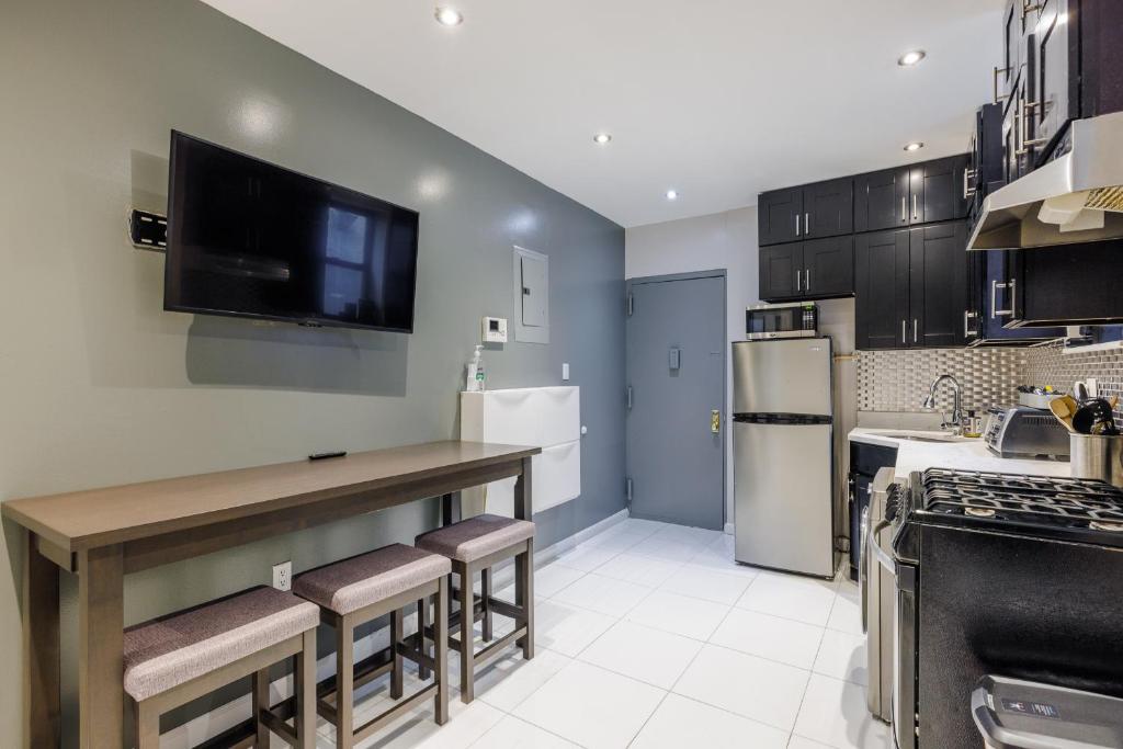 a kitchen with a counter and a tv on the wall at Home is Where the Park is in New York