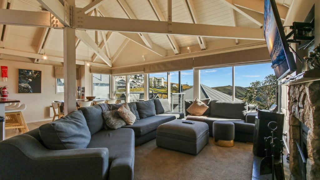a large living room with a blue couch and chairs at 1-8 Hot Plate in Mount Hotham