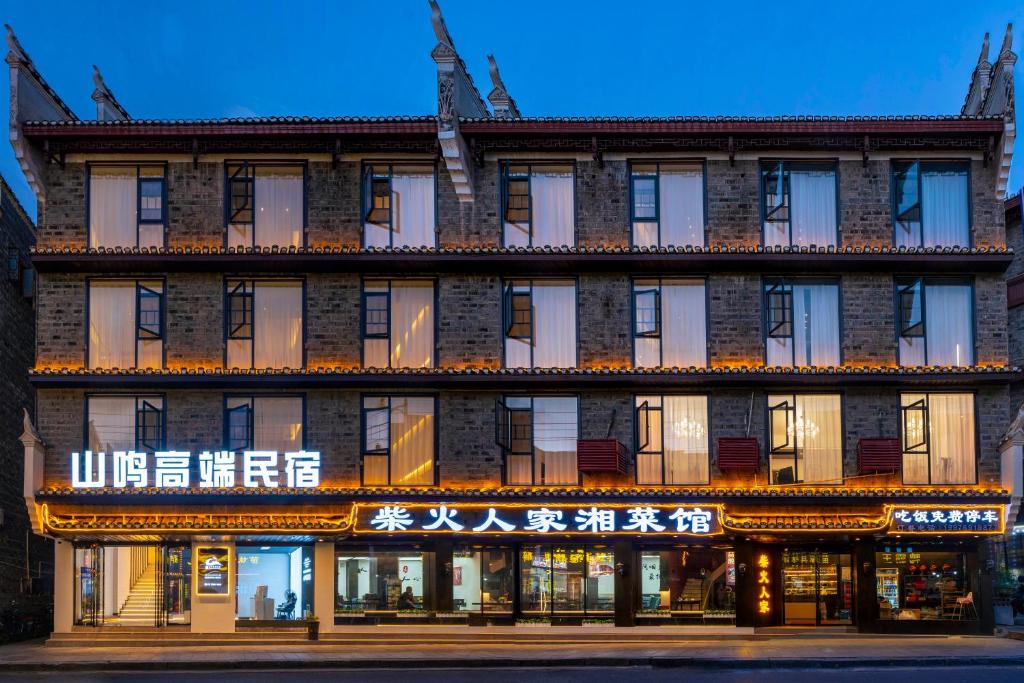 un edificio con escritura china en la parte delantera. en Shanming Boutique Homestay, en Fenghuang