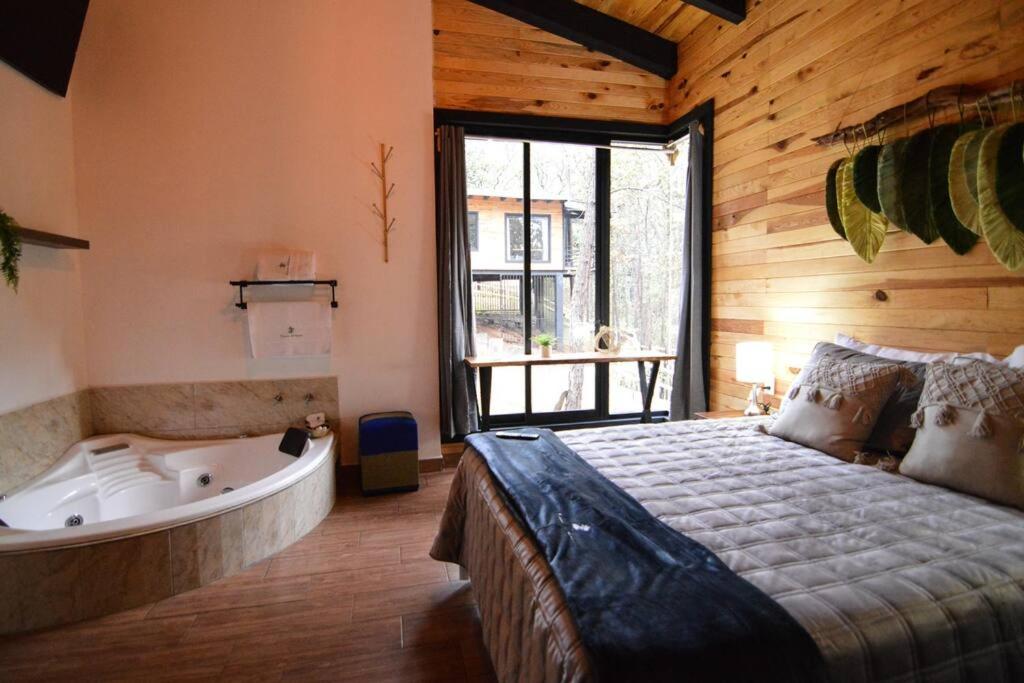 マサミトラにあるCabaña Cedrelaのベッドルーム1室(ベッド1台、バスタブ、ベッド1台、バスタブ付)