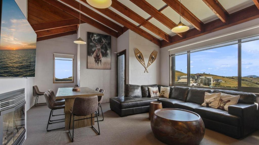 a living room with a couch and a table at 1750 Hotham 12 in Mount Hotham