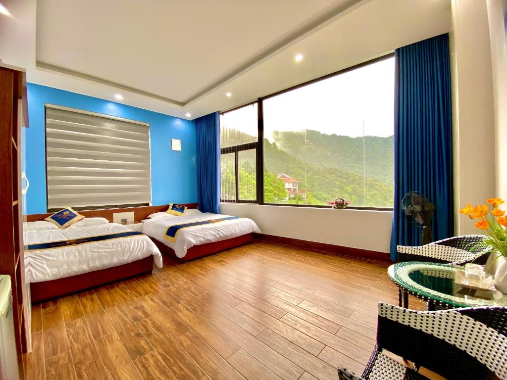 a bedroom with two beds and a large window at Hương Trà Villa - Hotel Tam Đảo in Tam Ðảo