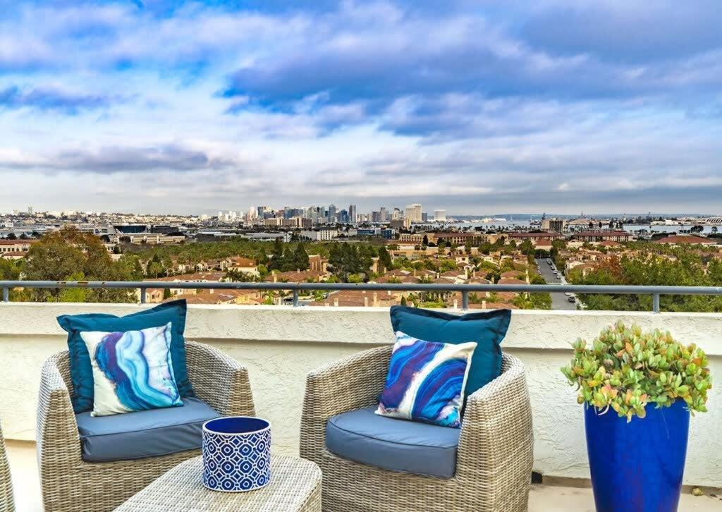 a balcony with wicker chairs and a view of the city at Spacious Beautiful Home with Stunning Bay Views in San Diego