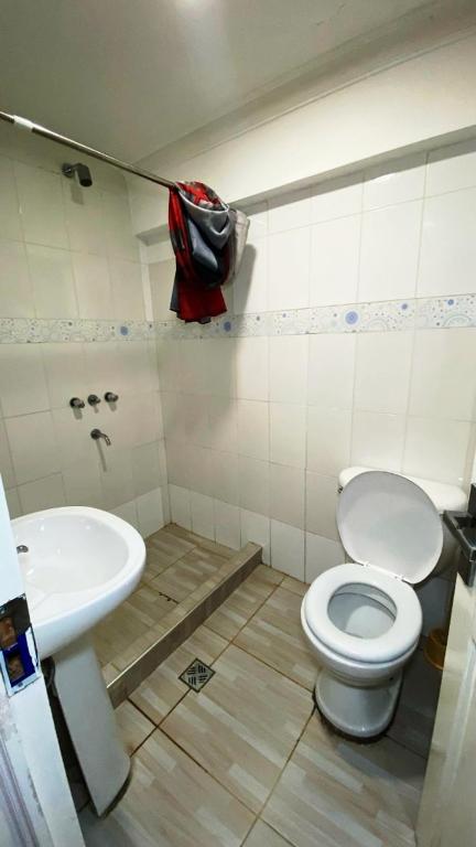 a bathroom with a toilet and a sink at Acogedora Habitación in Sucre