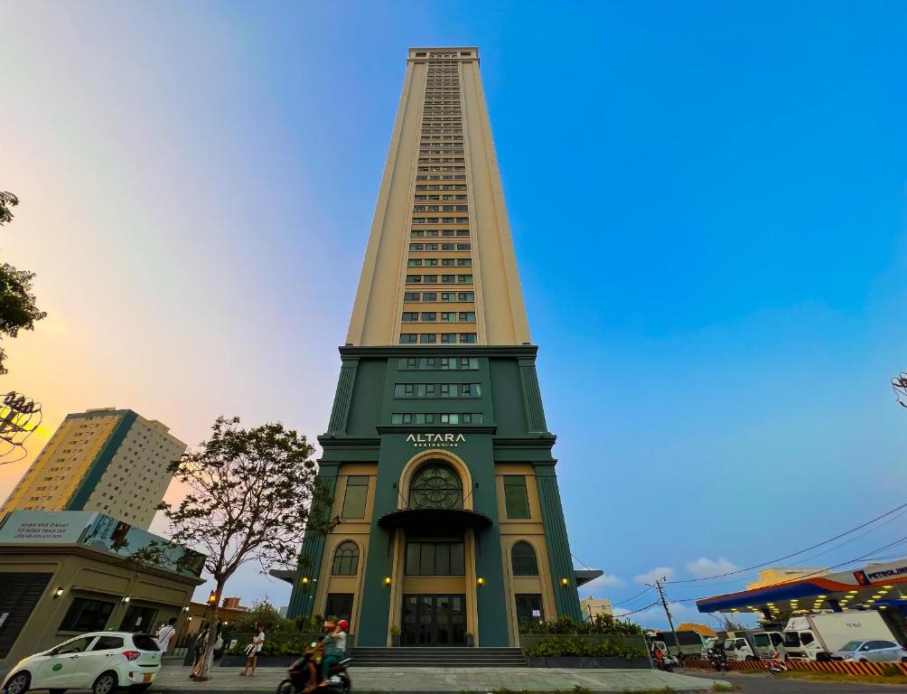 a tall green and yellow clock tower in a city at Altara Quy nhơn Residences Wins in Quy Nhon