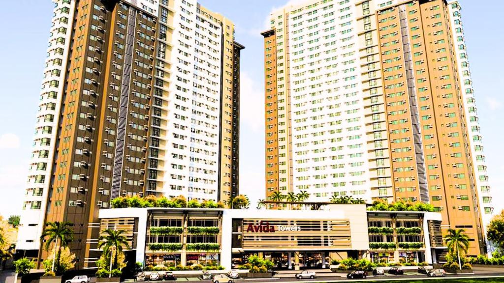 zwei hohe Gebäude mit Palmen davor in der Unterkunft Modern Designed Studio Condo Near Ayala Centrio in Cagayan de Oro