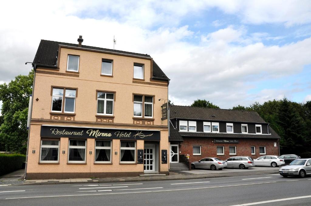 a building on a street with cars parked in front of it at Hotel Restaurant Mirena in Marl