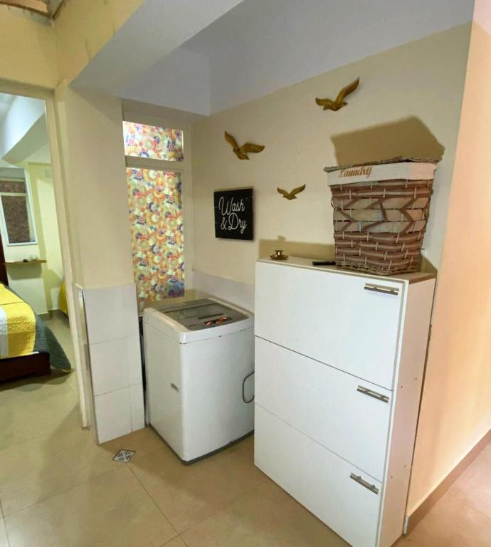 a room with a refrigerator and birds on the wall at Encantadora habitación in Sucre