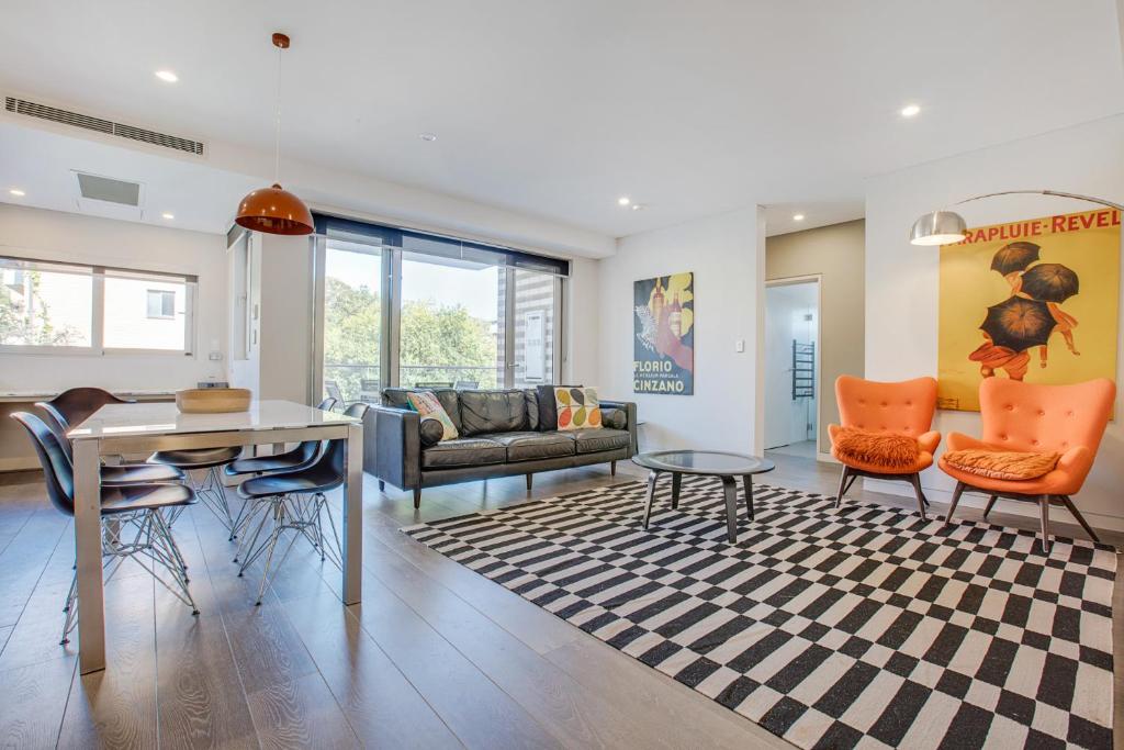 a living room with a couch and a table and chairs at Cosy 1-Bedroom Apartment Close to the City in Sydney