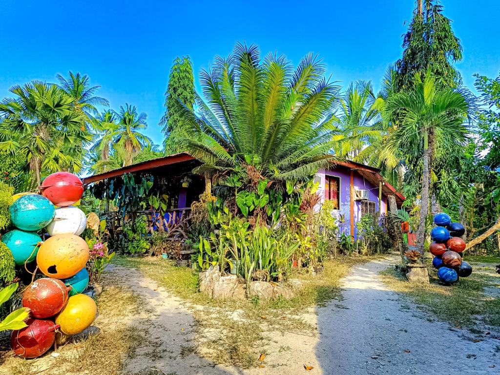 una casa con palmeras y globos coloridos delante de ella en A. Zaragosa Lodging House, en Inandeng