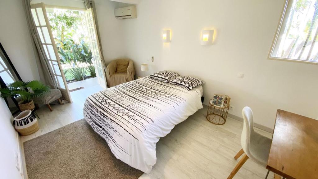 a bedroom with a bed and a table and chairs at COLIVER - COLIVING A LA RÉUNION in Saint-Pierre