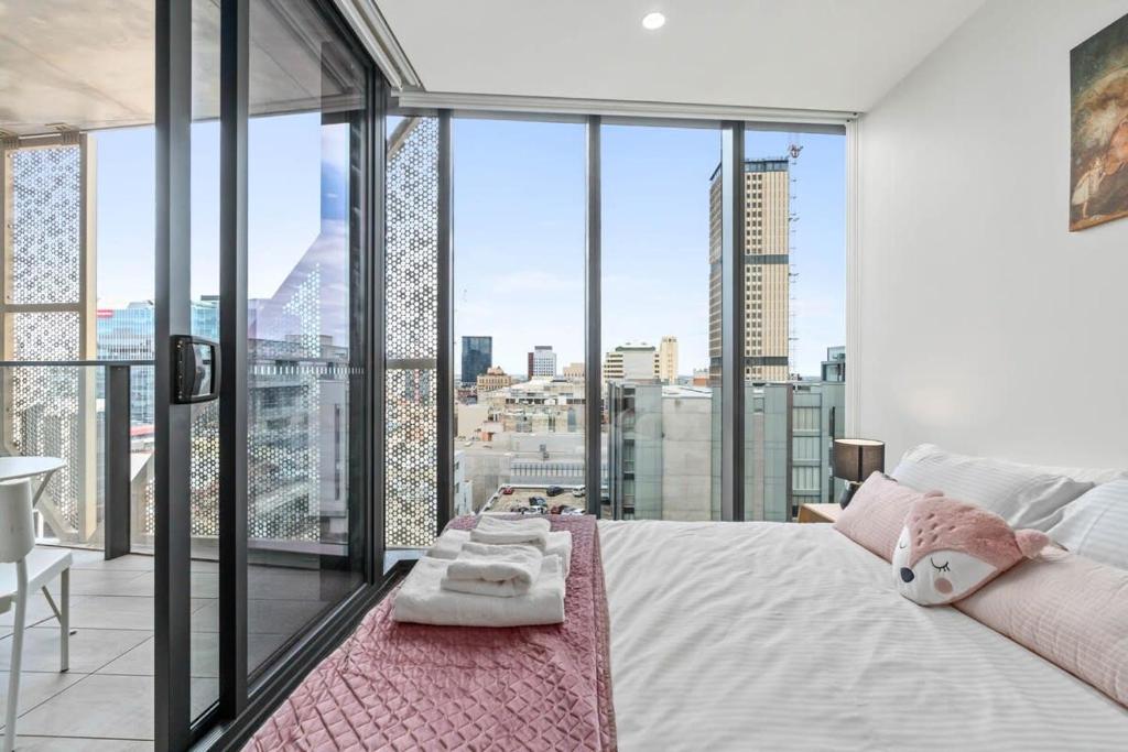 a bedroom with a bed with a view of a city at Taffy on Realm RundleMall Pool&Gym EasyLifestyle in Adelaide