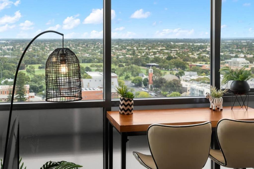 een vogelkooi op een tafel voor een raam bij Comfy place with fabulous view Penthouse level in Adelaide