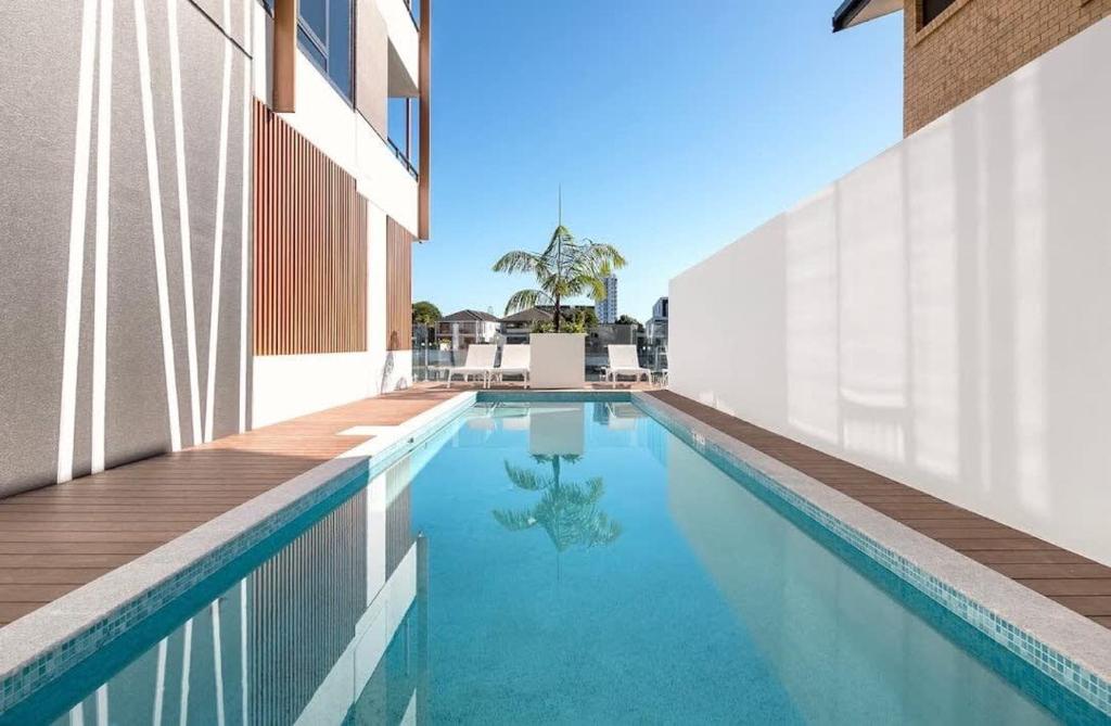a swimming pool next to a building at Surf's Up Stunning Paradise Apartment Serenity in Gold Coast
