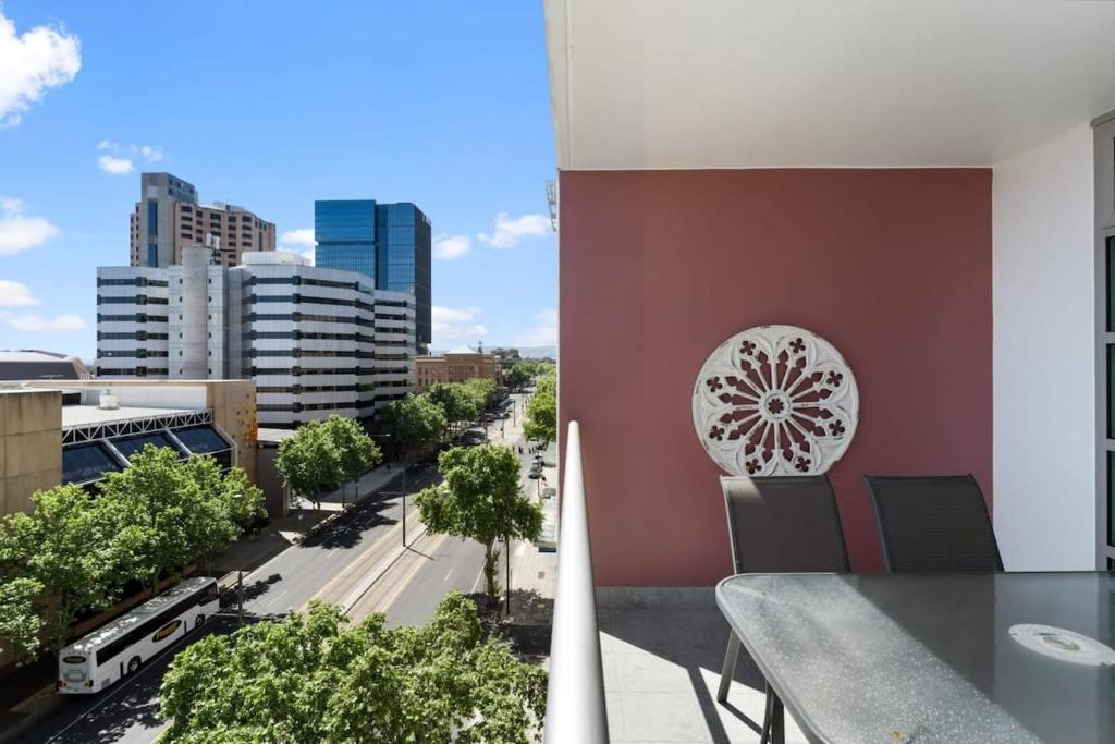 een balkon met een tafel en uitzicht op de stad bij CBD 2BR Apartment at 96 North Tce - Free Parking in Adelaide
