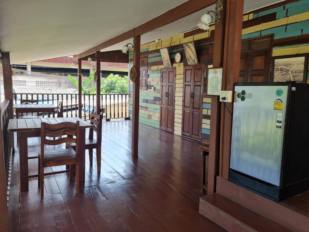 um quarto com uma mesa e uma televisão num alpendre em Lamour Guesthouse ละเมอ เกสต์เฮาส์ em Pattaya North