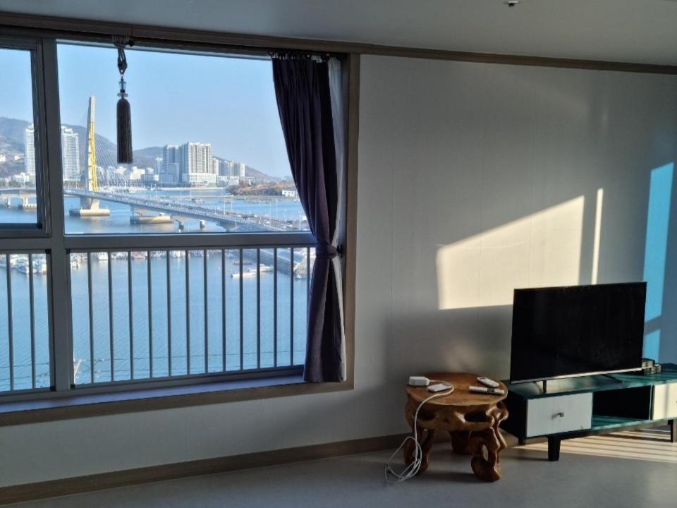 a room with a large window with a view of a river at Yeosu Rex Haesoo Resort in Yeosu