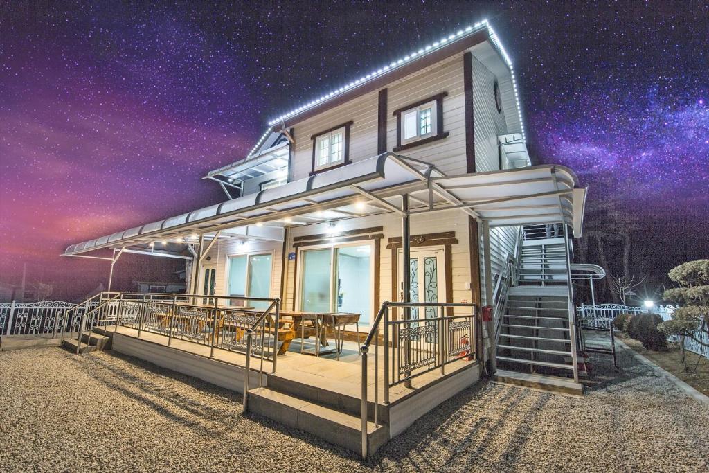 a house with a starry sky in the background at Muchangpo Chamjoeun Pension in Boryeong