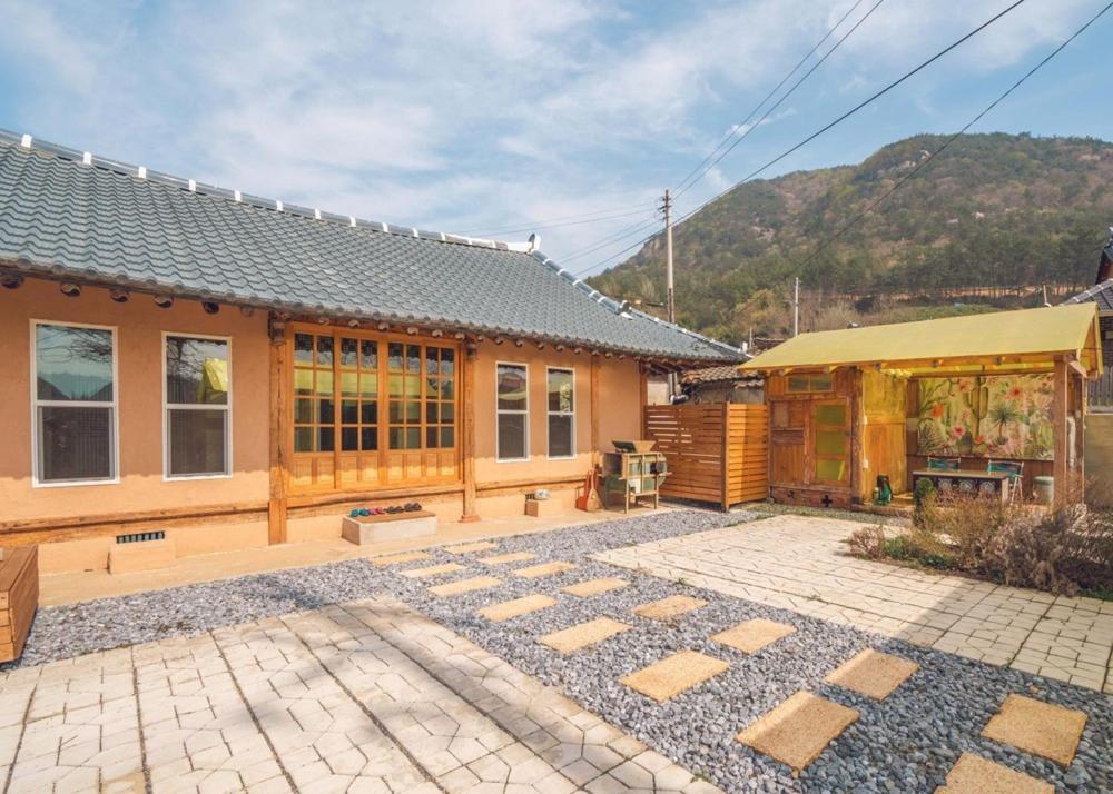 a house with a patio in front of a building at Goheung Namsoonjae Hanok Stay in Goheung