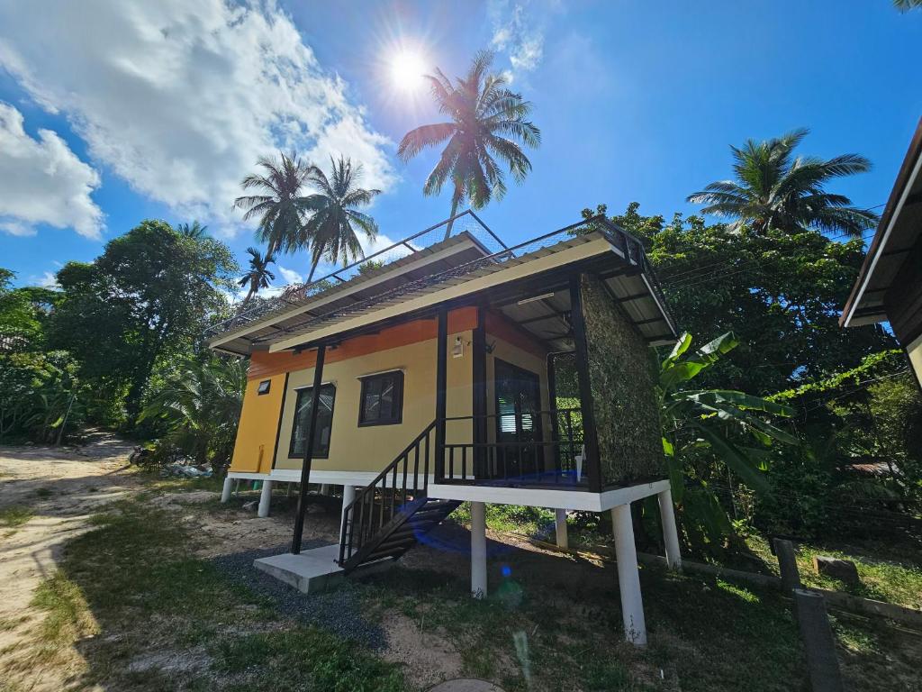 ein winziges Haus am Strand mit Palmen in der Unterkunft Srithanu Haus in Haad Chao Phao