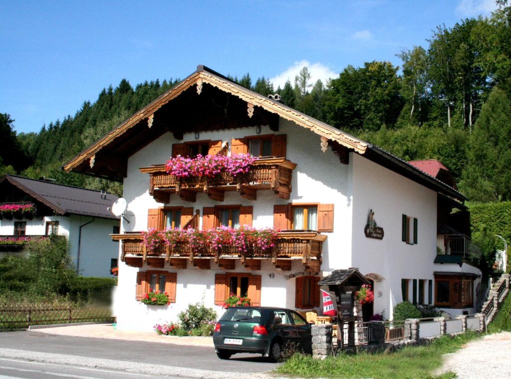 a white house with flower boxes on the windows at Haus Appesbacher in St. Wolfgang
