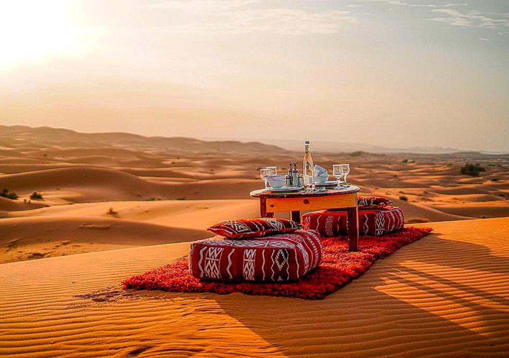 a table in the middle of the desert at Amazing Luxury Camp in Merzouga