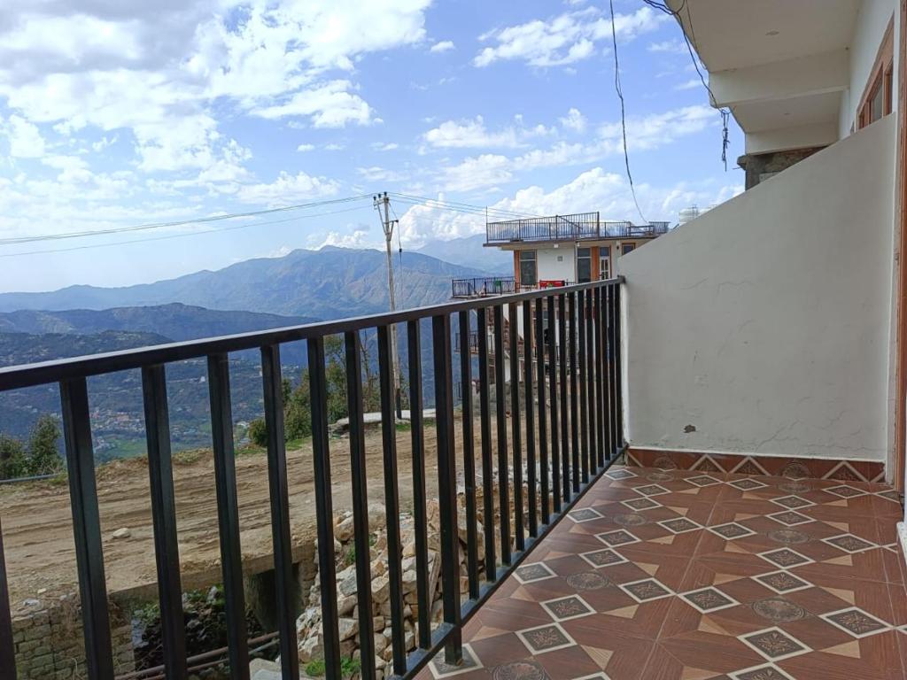 uma varanda com vista para as montanhas em HA Talai Village Homes em Dalhousie