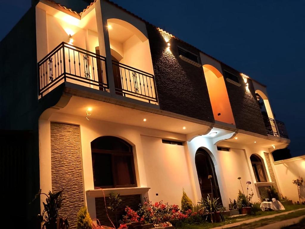 a large white house with a balcony at night at Hotel Terravolcan in La Tenería