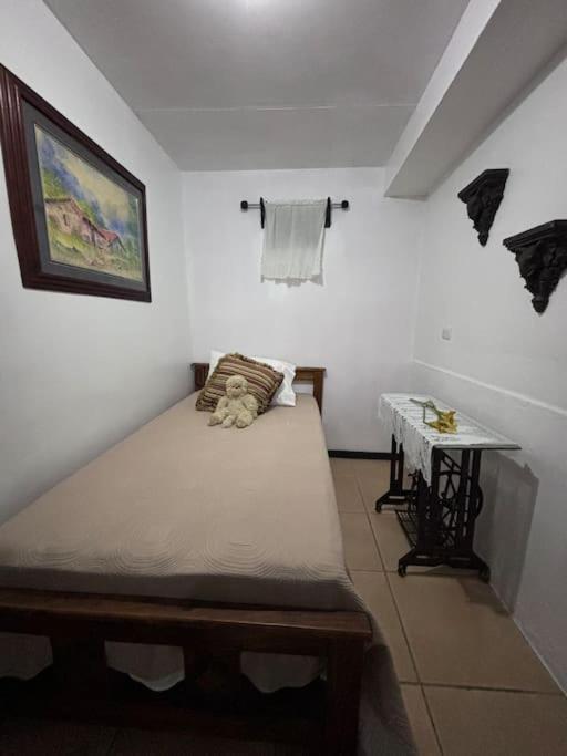 a small bedroom with a bed and a table at 444, Rincón de paz in Alajuela City