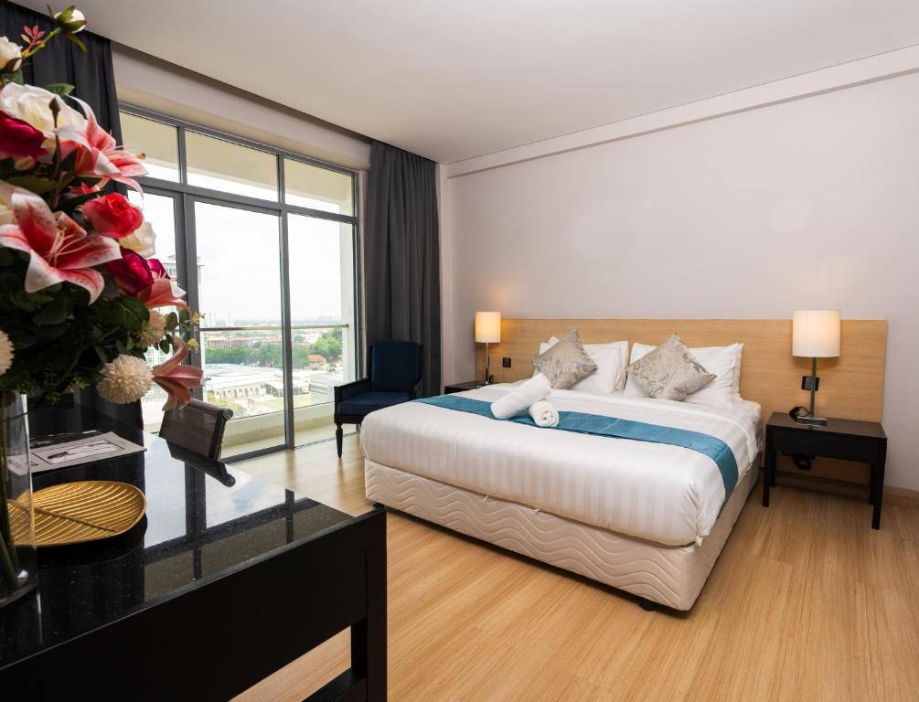 a hotel room with a bed and a large window at The Straits Melaka by Perfect Host in Melaka