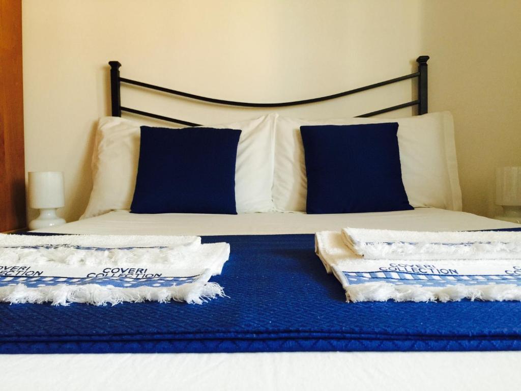 ローマにあるThe 7th Floor in Romeのベッドルーム1室(青と白の枕が備わるベッド1台付)