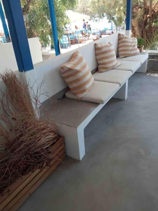 a white bench with pillows on it on a patio at Marditsa's House by the sea in Serifos Chora